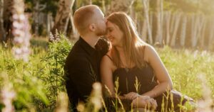 A couple pose in a field in Flagstaff, one of the 5 best summer engagement session locations in Arizona