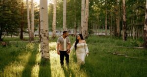 A couple pose in a field in Flagstaff, one of the 5 best summer engagement session locations in Arizona