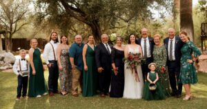 A bride and groom pose with their family at their Tucson wedding at Wildhorse ranch.