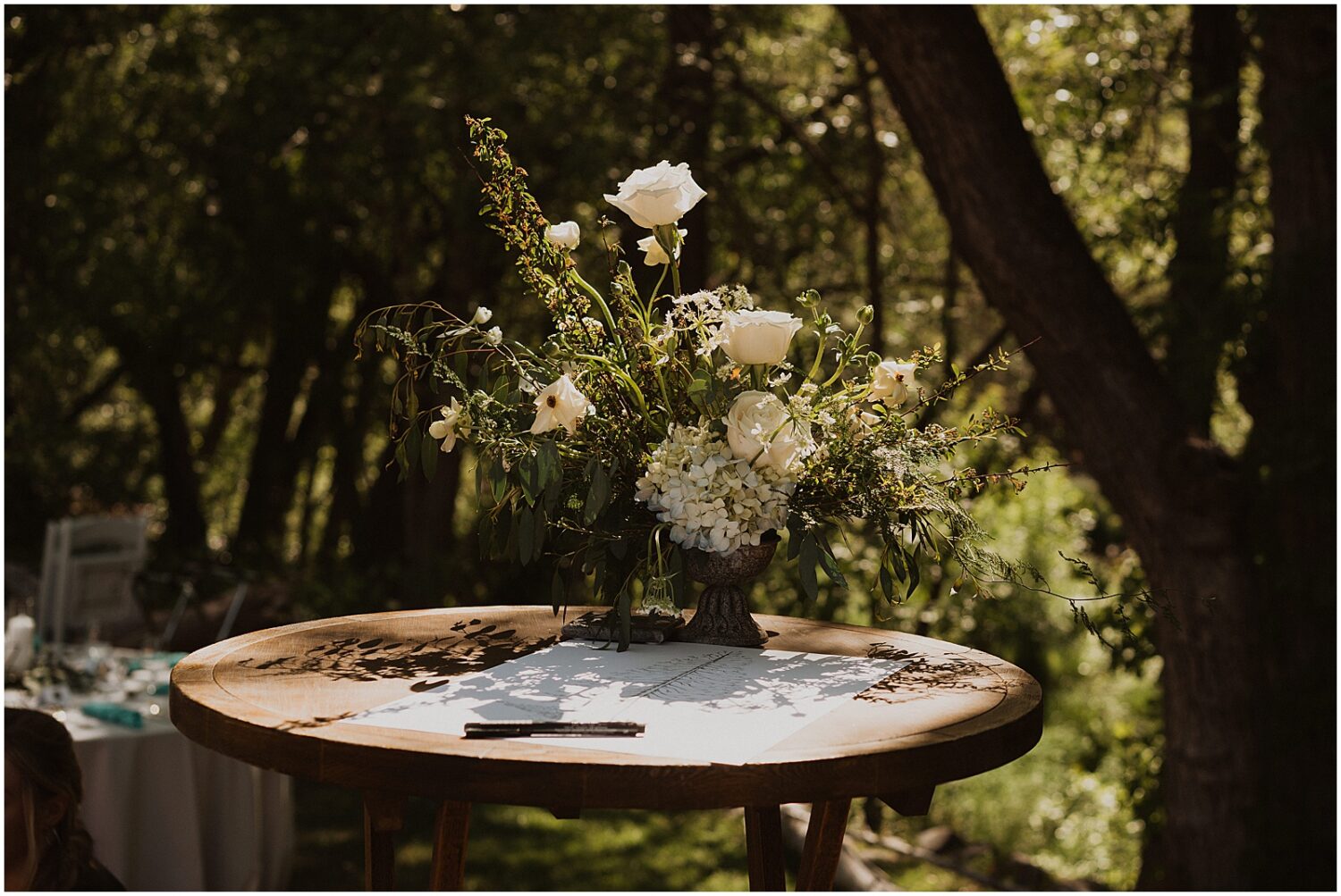 A wedding bouquet sits on a table in a patch of sun.