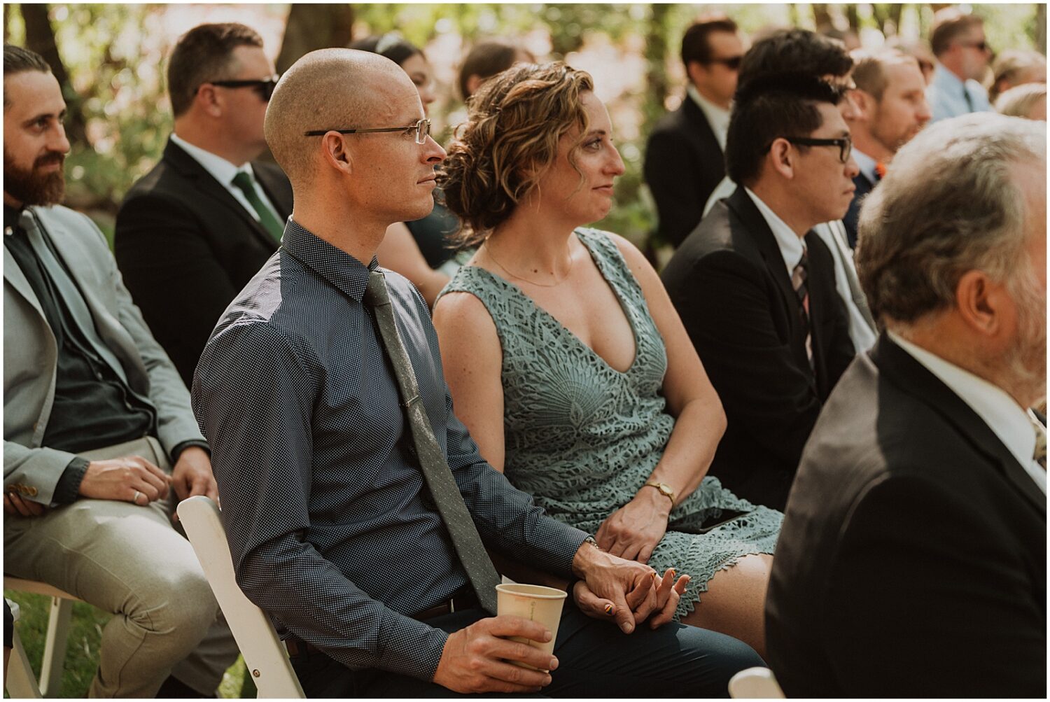 Wedding guests hold hands during a ceremonny.