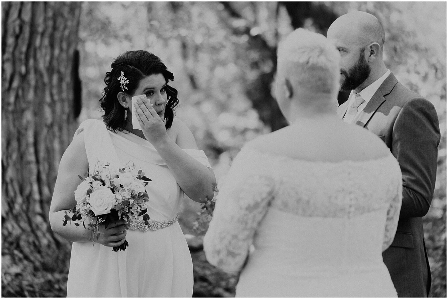 A bride wipes away a tear during a Sedona wedding ceremony.