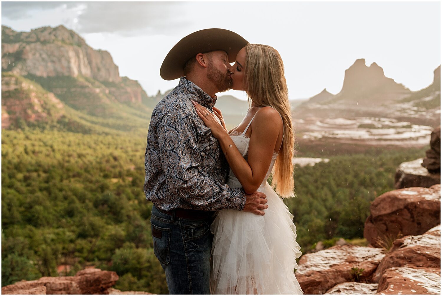 A man and woman kiss in an Arizona engagement photo.