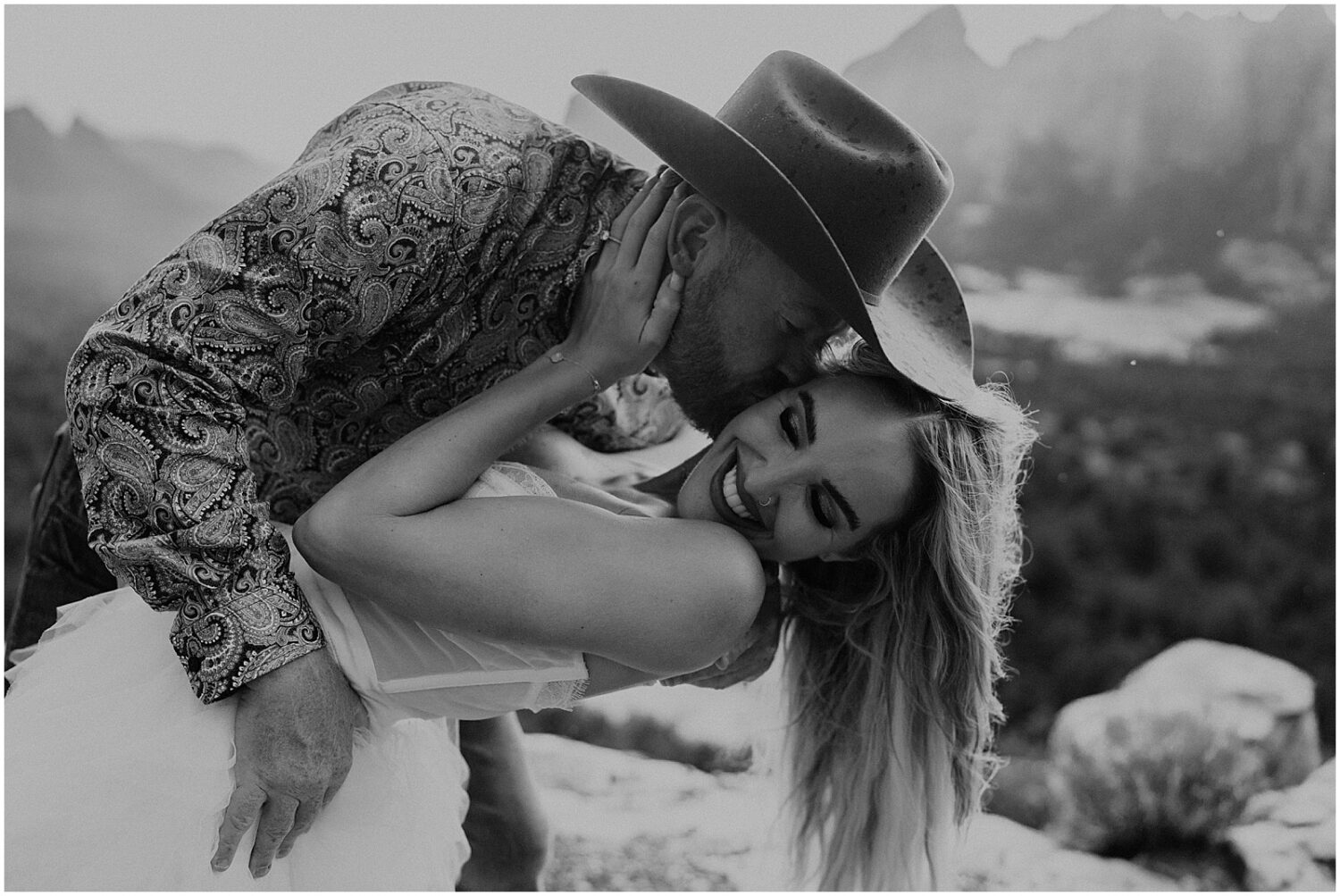 A woman laughs as a man kisses her cheek in an Arizona engagment photo.