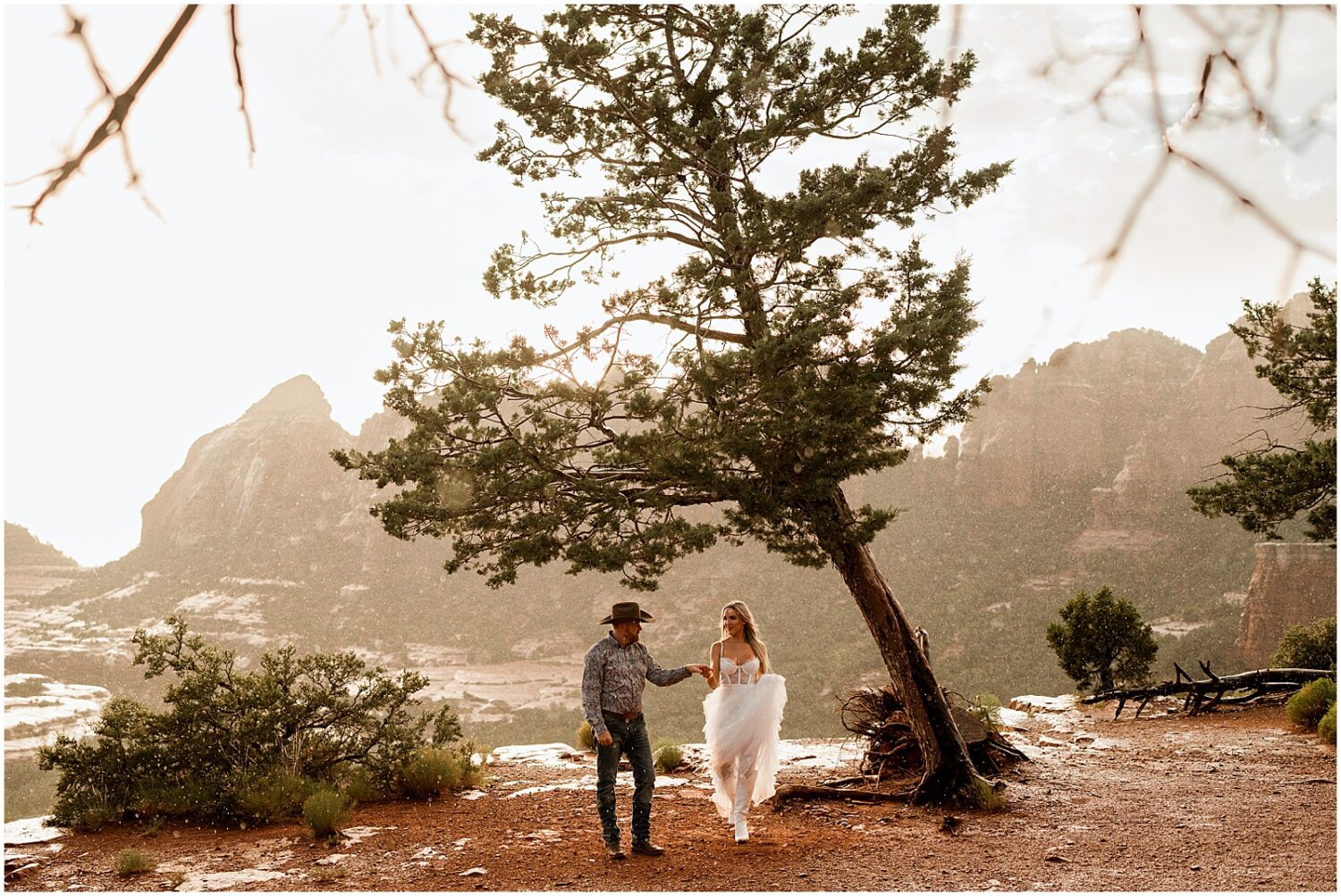 A man and woman walk past a tree outside Sedona.
