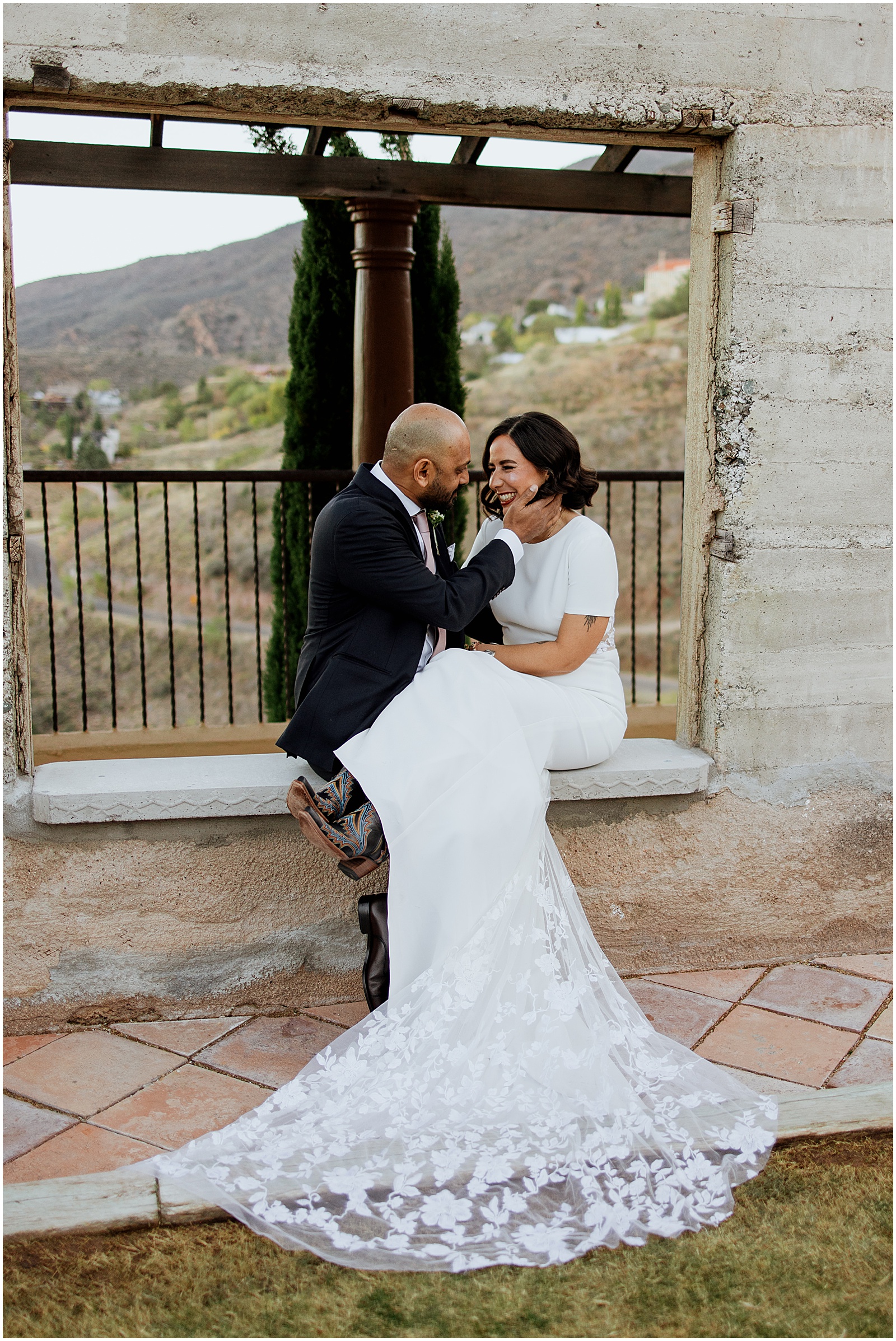 A bride and groom sit on a windowsill at the Little Daisy Jerome.