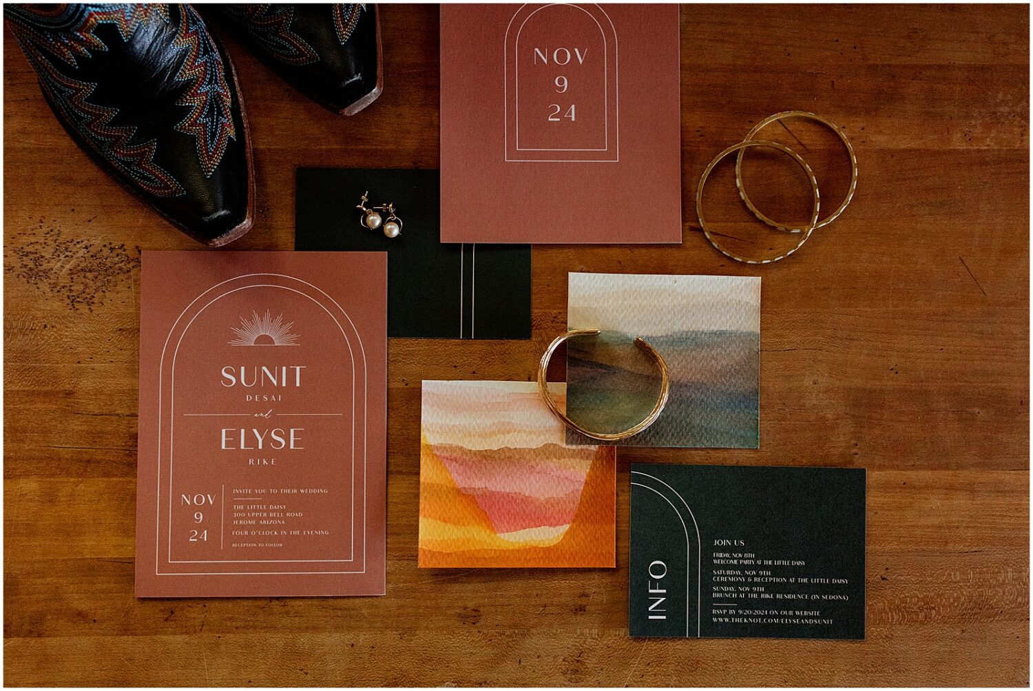 An invitation suite sits on wooden table.