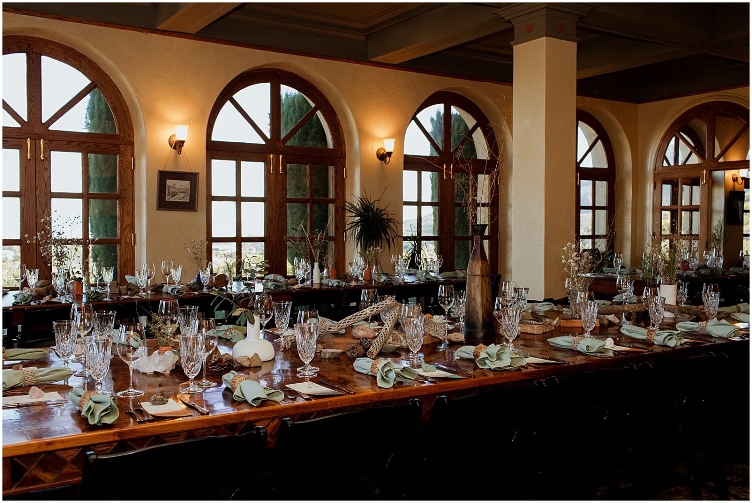 Long tables are set for a wedding reception in a ballroom at the Little Daisy Jerome.