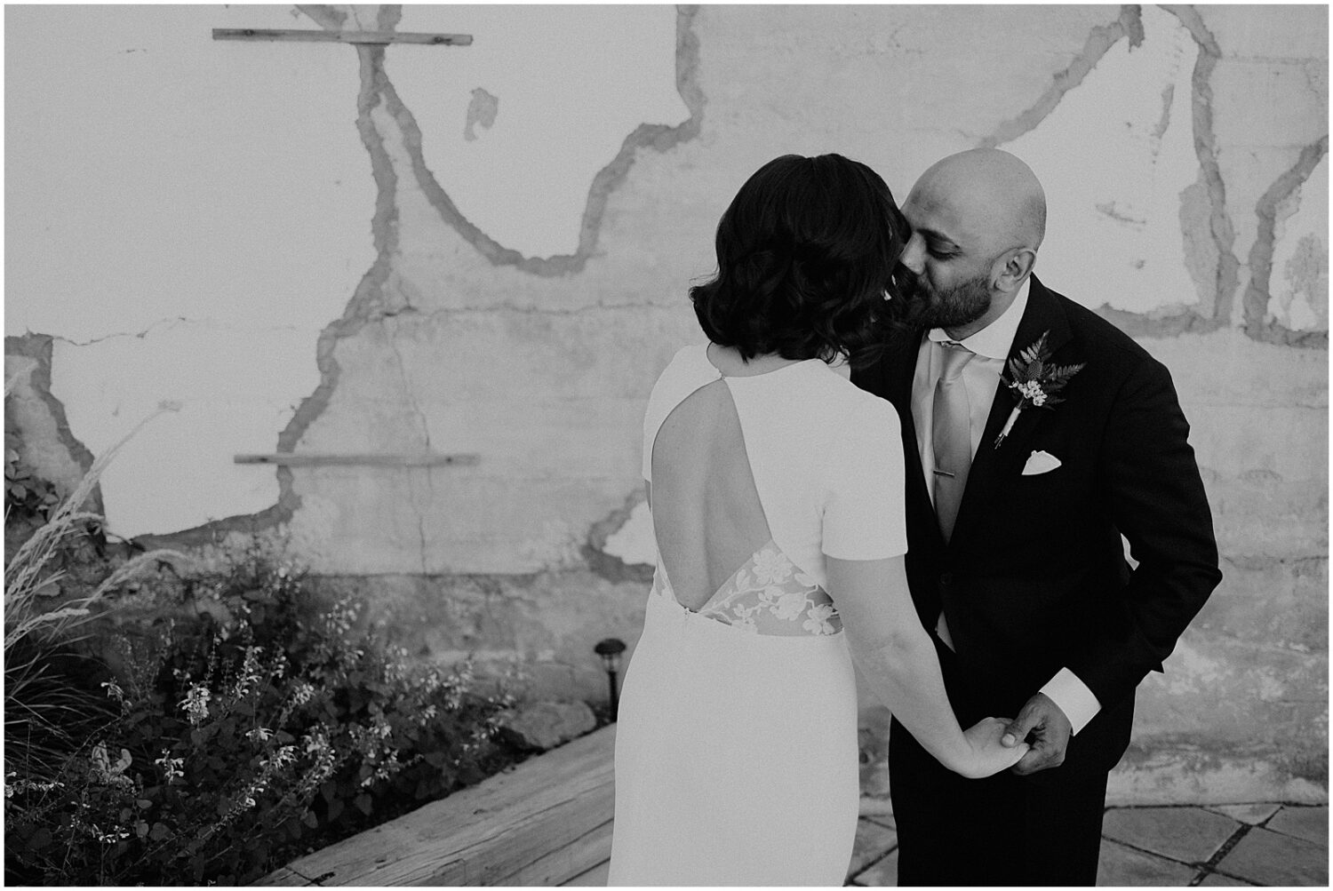 A groom kisses a bride's cheek outside a Jerome hotel.