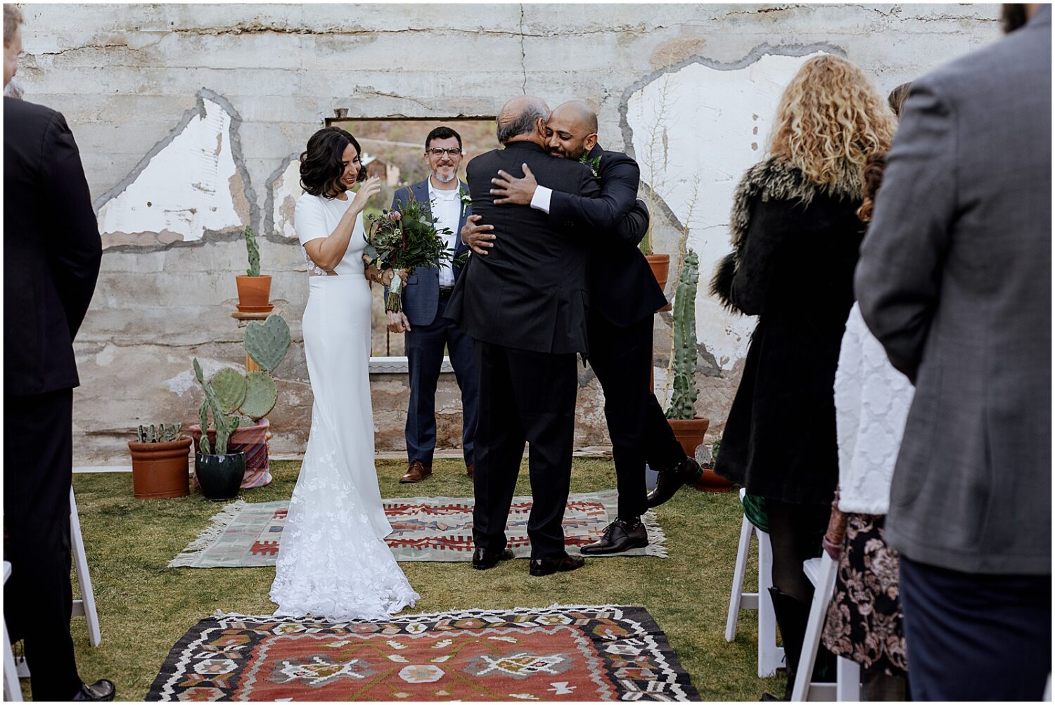 A bride's father hugs a groom before a wedding ceremony at the Little Daisy Jerome.