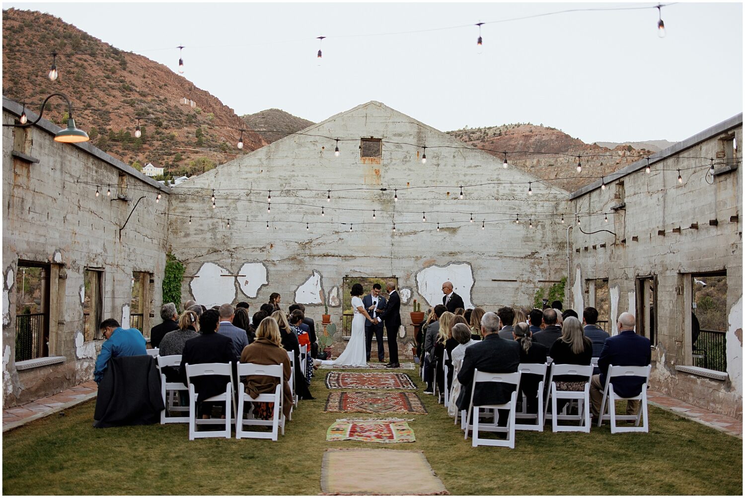 A bride and groom stand in front of wedding guests for a ceremony at the Little Daisy Jerome.