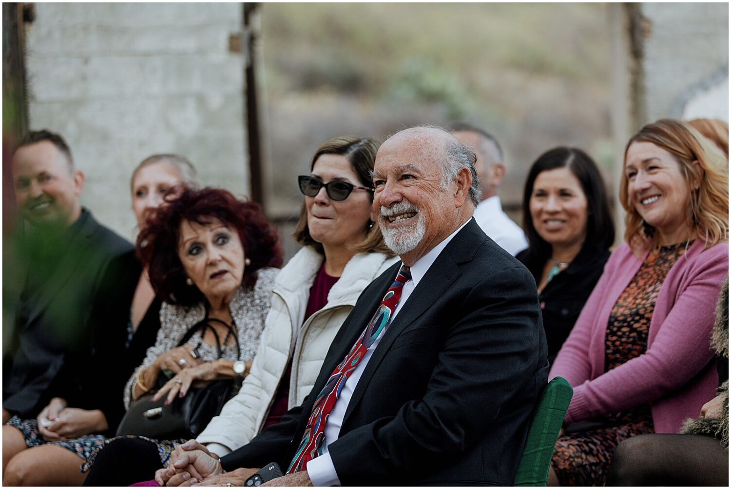 Family members smile during a wedding ceremony.
