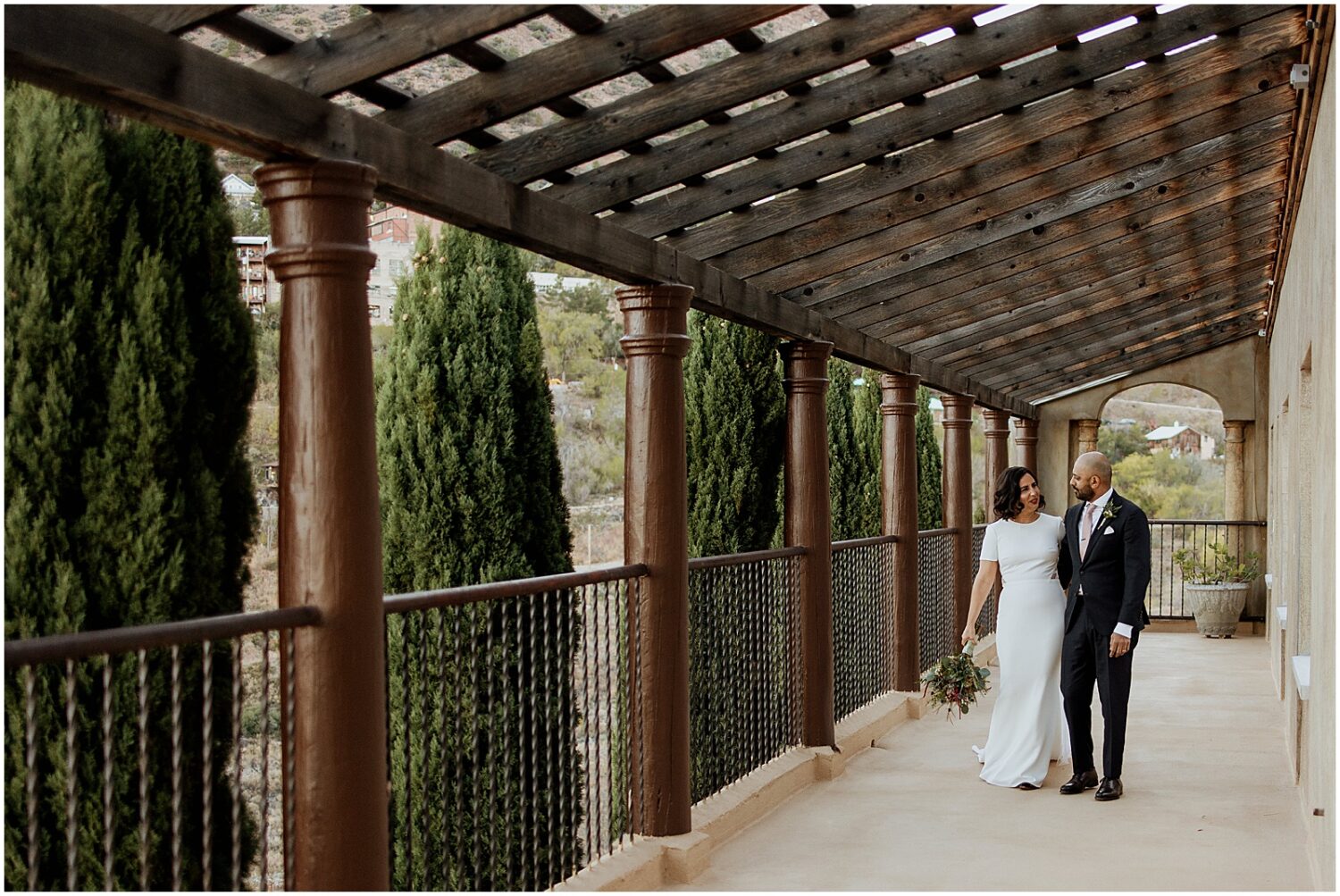 A bride and groom walk towards an Arizona wedding photographer in a Jerome wedding venue.