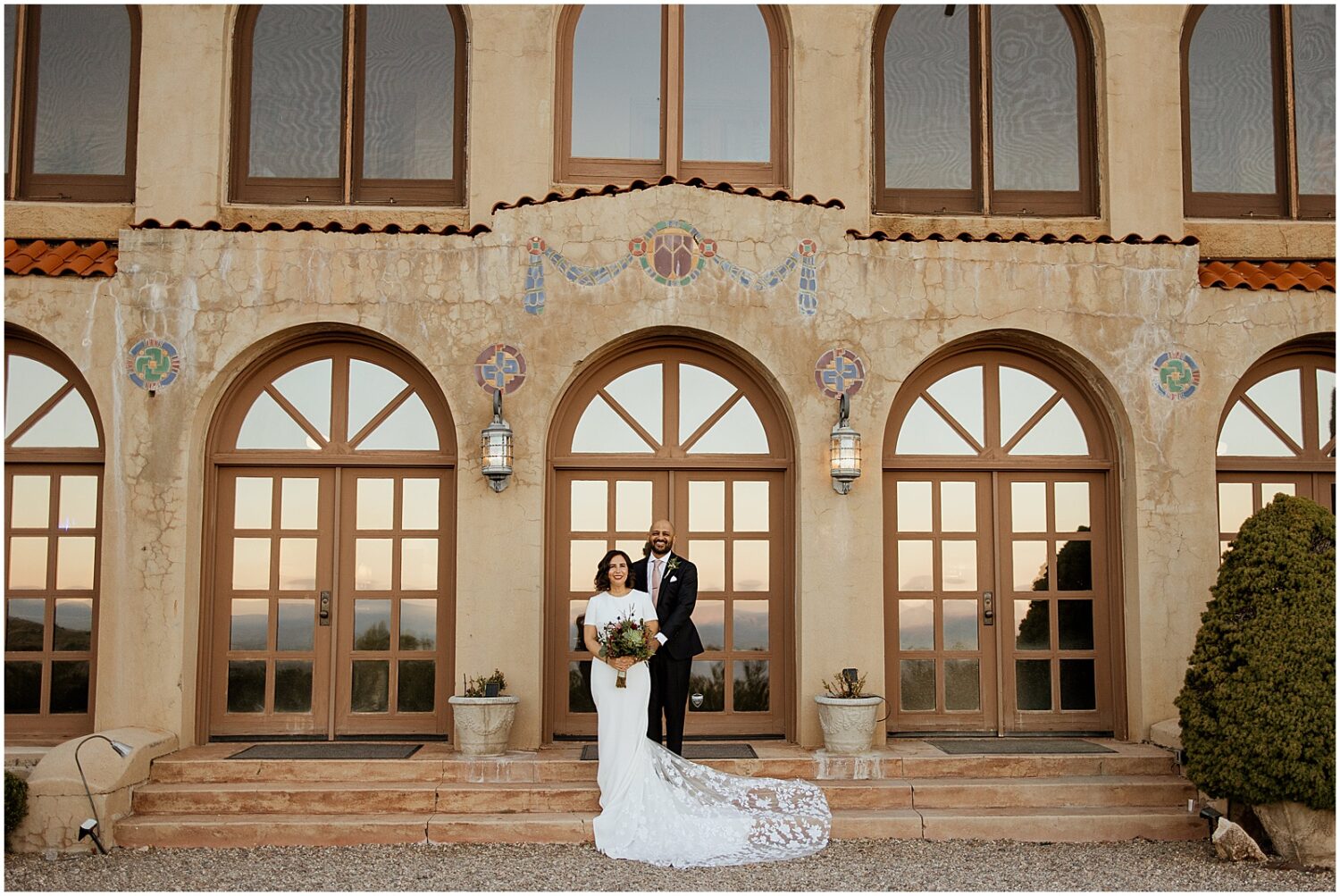 A bride and groom pose for an Arizona wedding photographer in front of the Little Daisy Jerome.