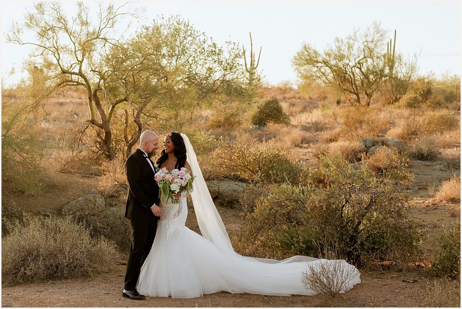 A bride and groom pose for sunset portraits in Apache Junction.
