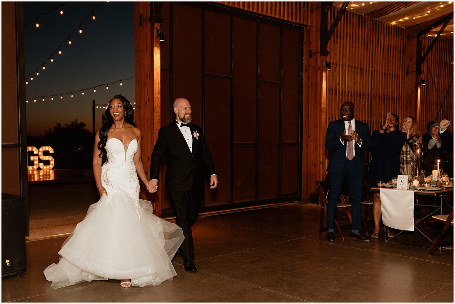 A bride and groom enter a reception at The Paseo.