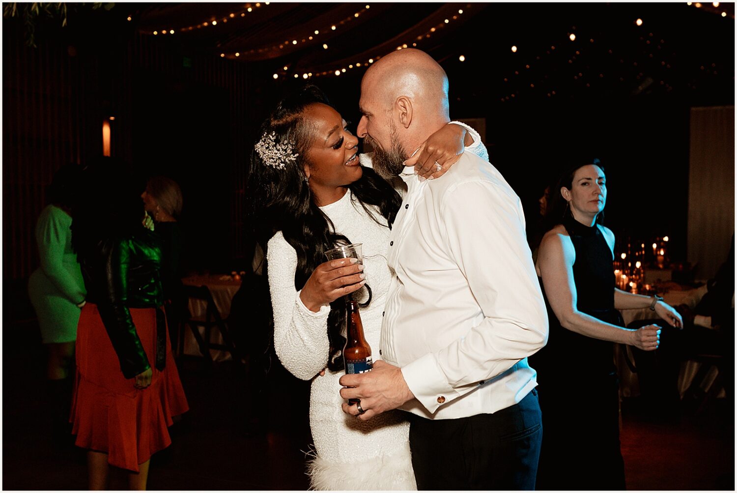 A bride in a reception dress dances with a groom.