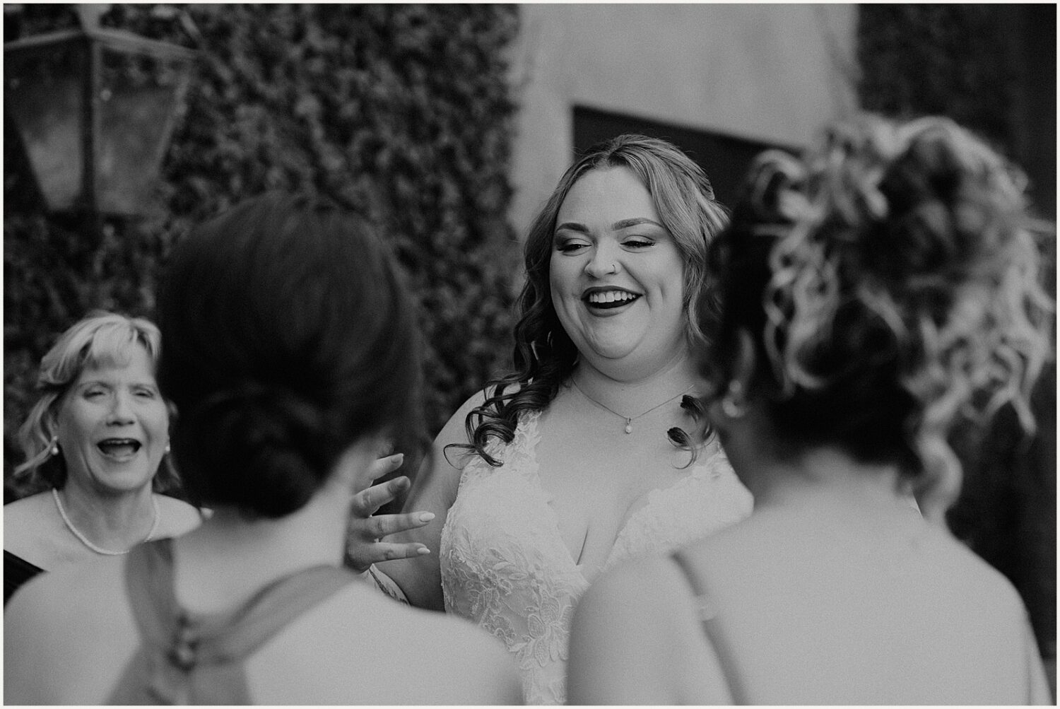 A bride smiles as she talks to her bridesmaids.