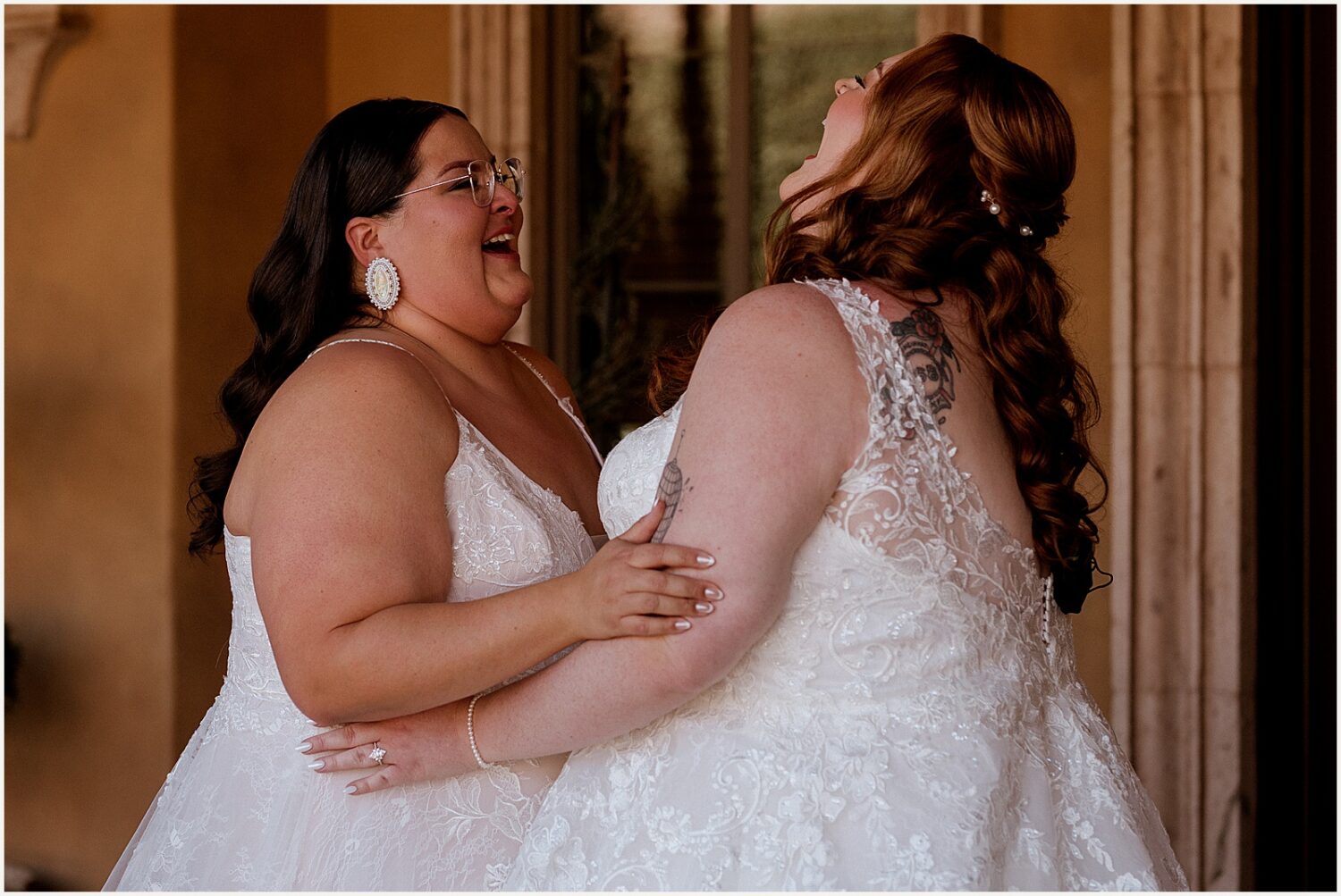 Two brides laugh at their first look.