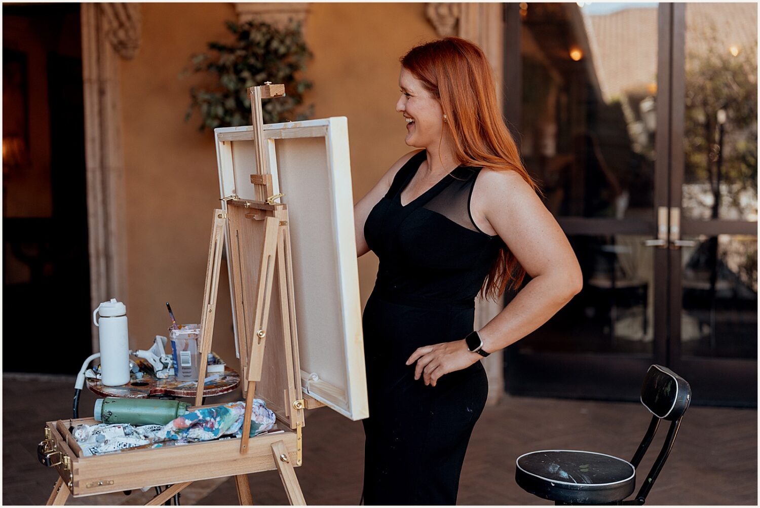 A live wedding painter stands at an easel at an Arizona wedding.