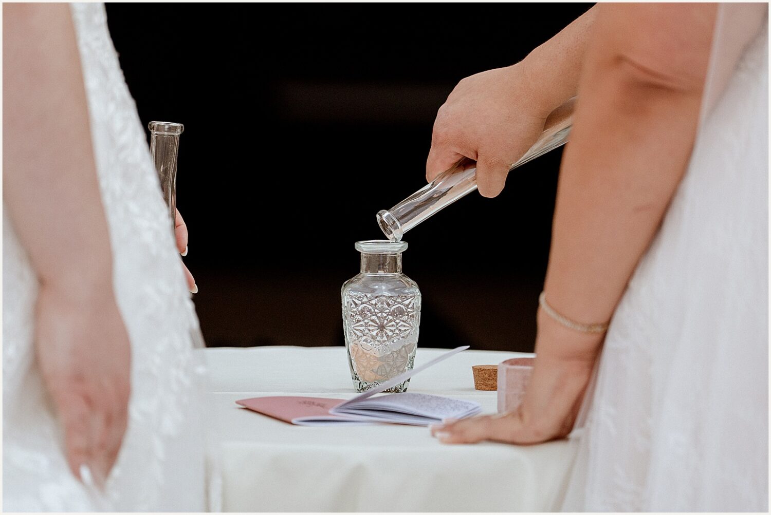 A bride pours water into a vase during a unity ceremony.