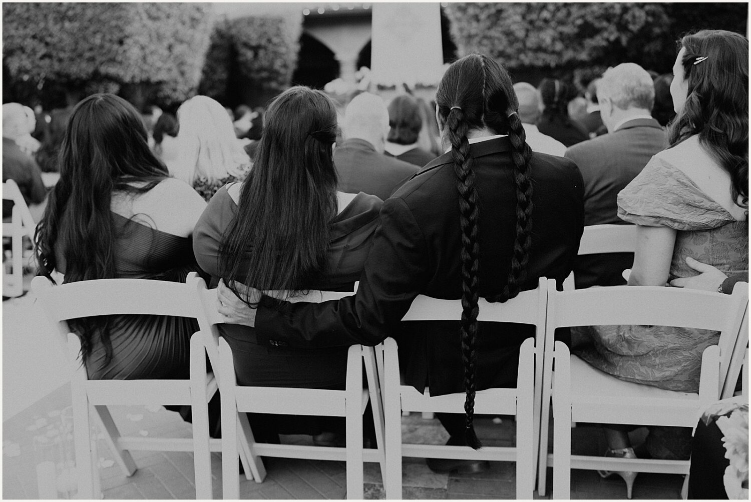 Wedding guests cuddle during a wedding ceremony.