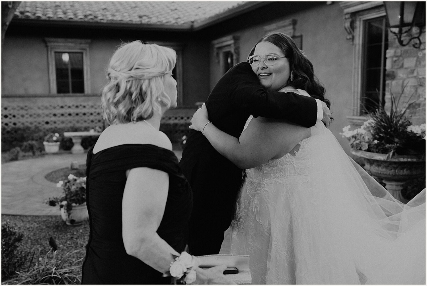 A bride hugs a family member.