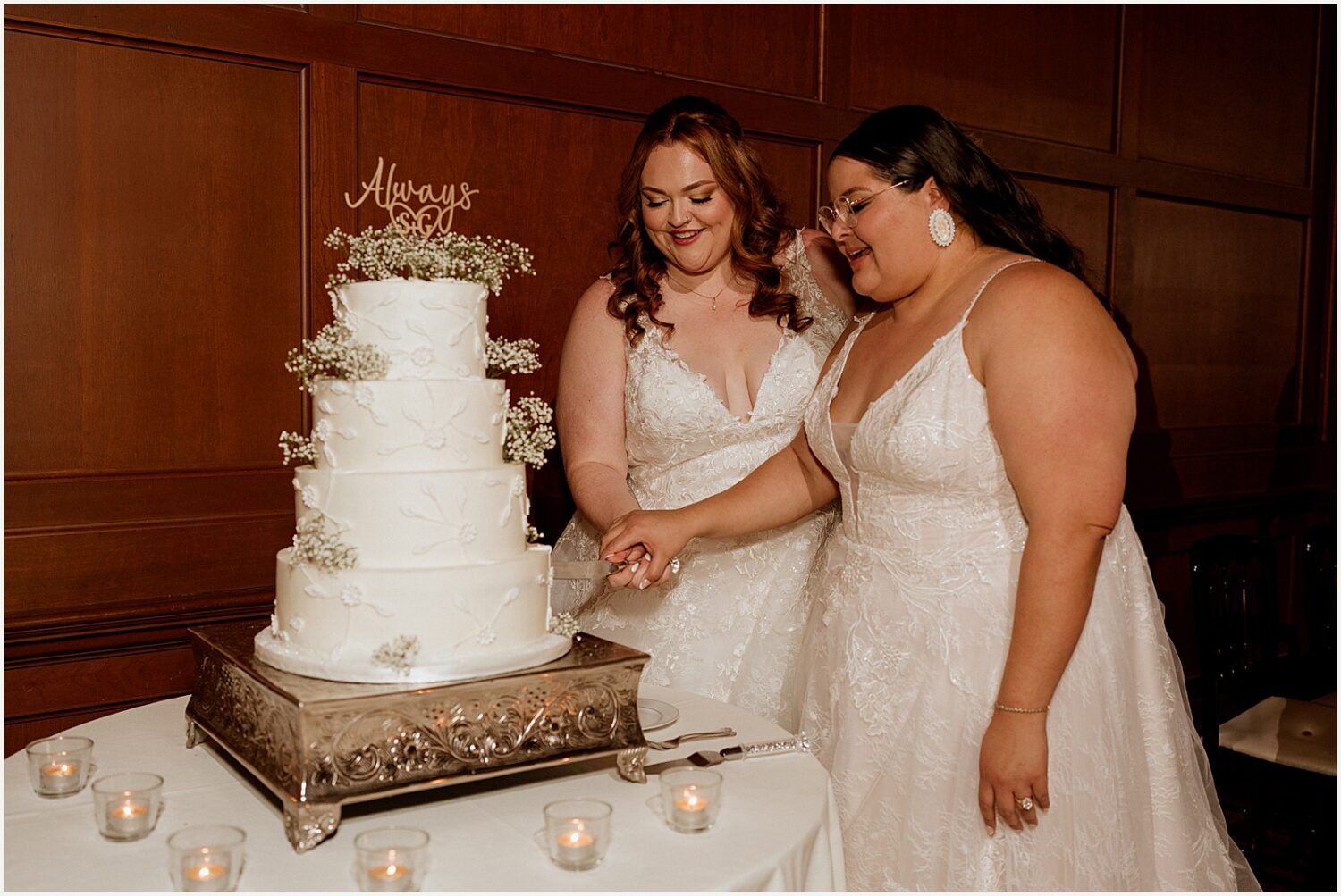 Two brides cut into a cake.