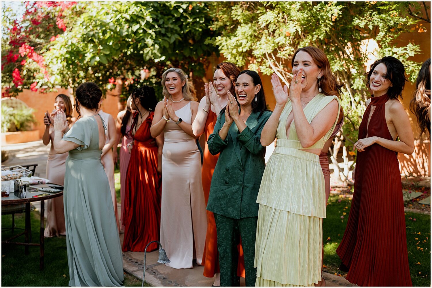 Bridesmaids cheer as two grooms arrive to an Arizona wedding.