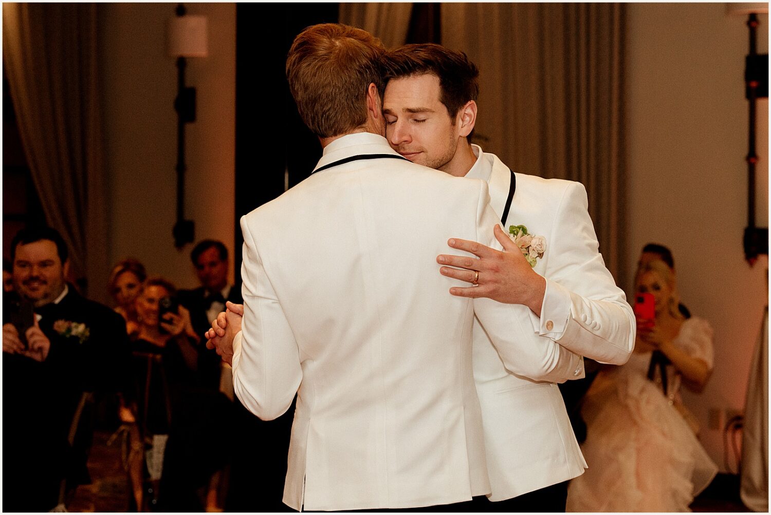 Two grooms dance close.