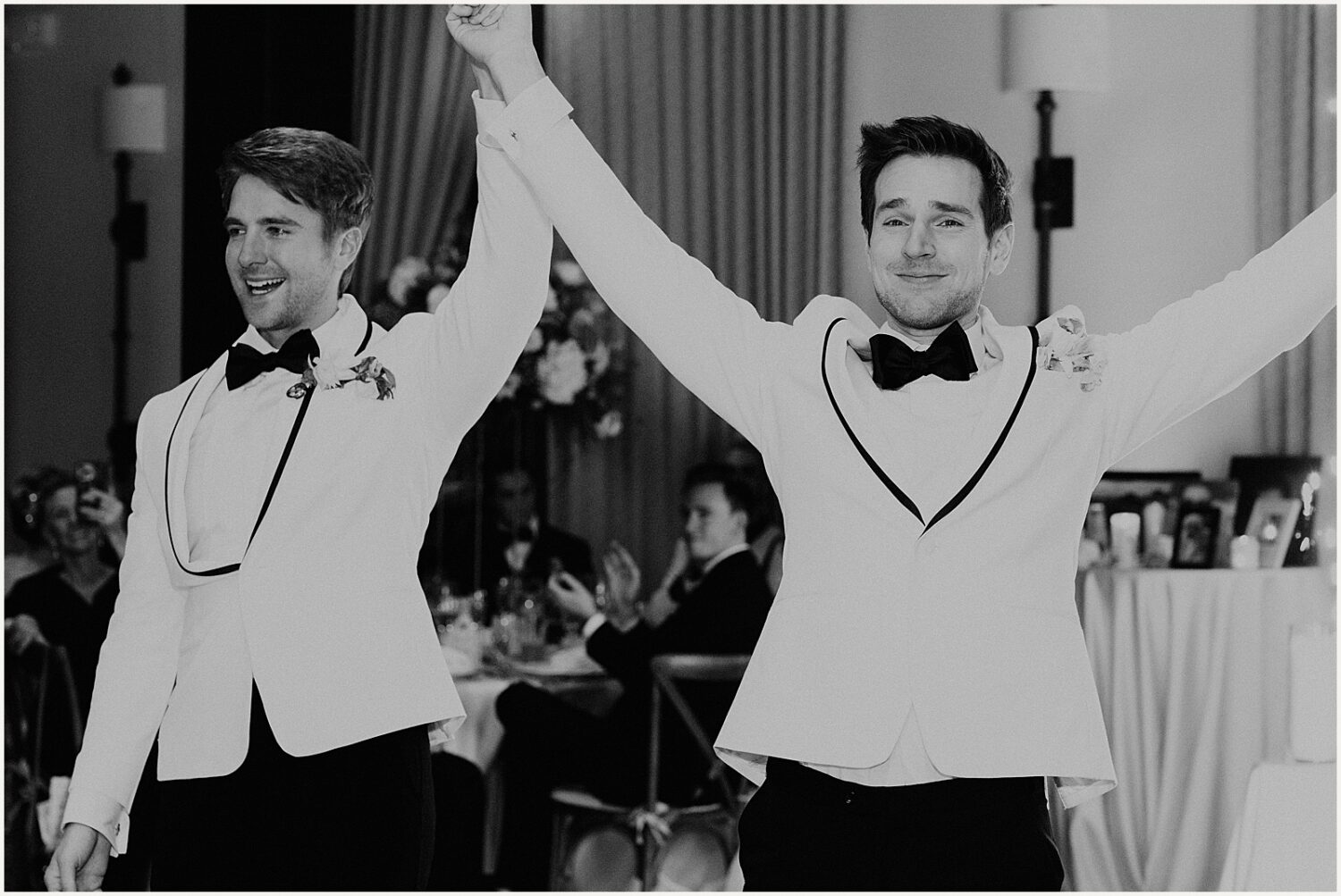 Two grooms enter a wedding reception.