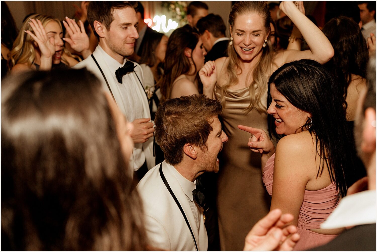 Two grooms dance with friends.