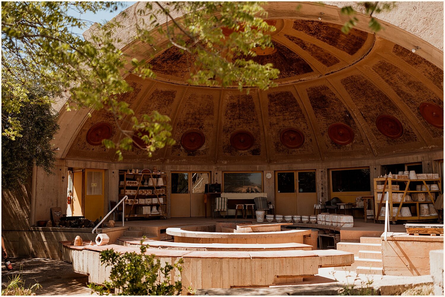 A bandshell in the desert is decorated with modern furniture.