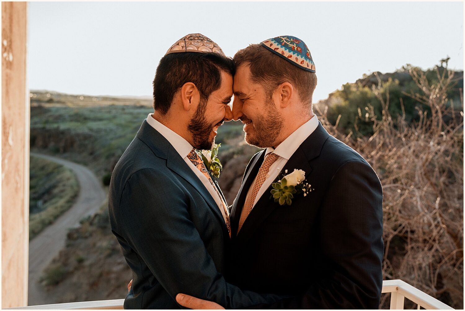 Two grooms smile and pose for Jewish wedding photography.