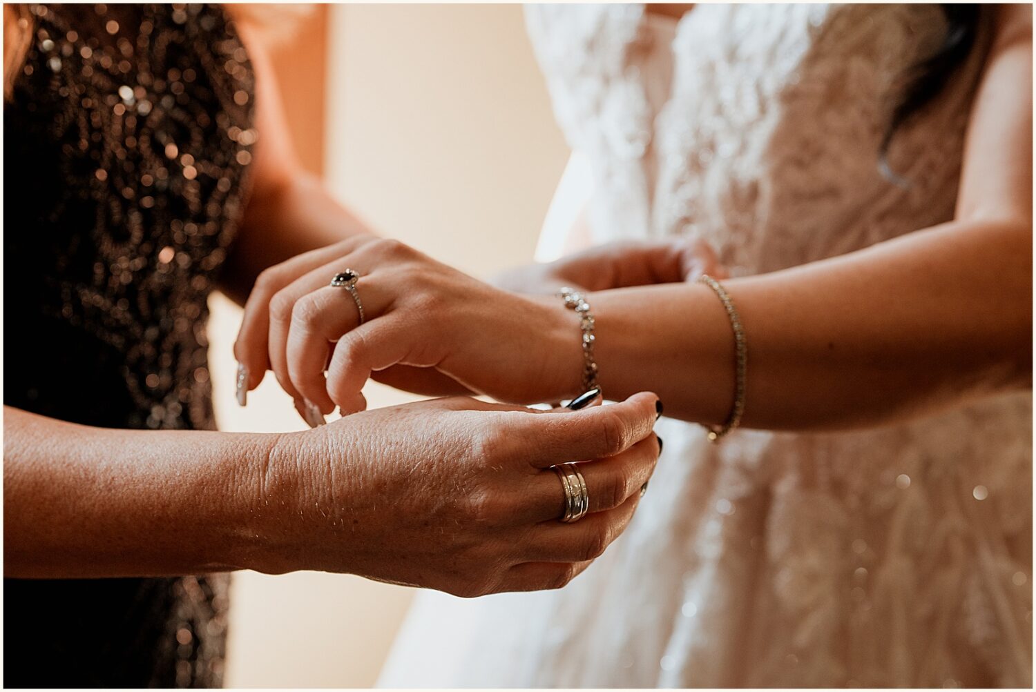 A bridesmaid puts a bracelet on a bride.