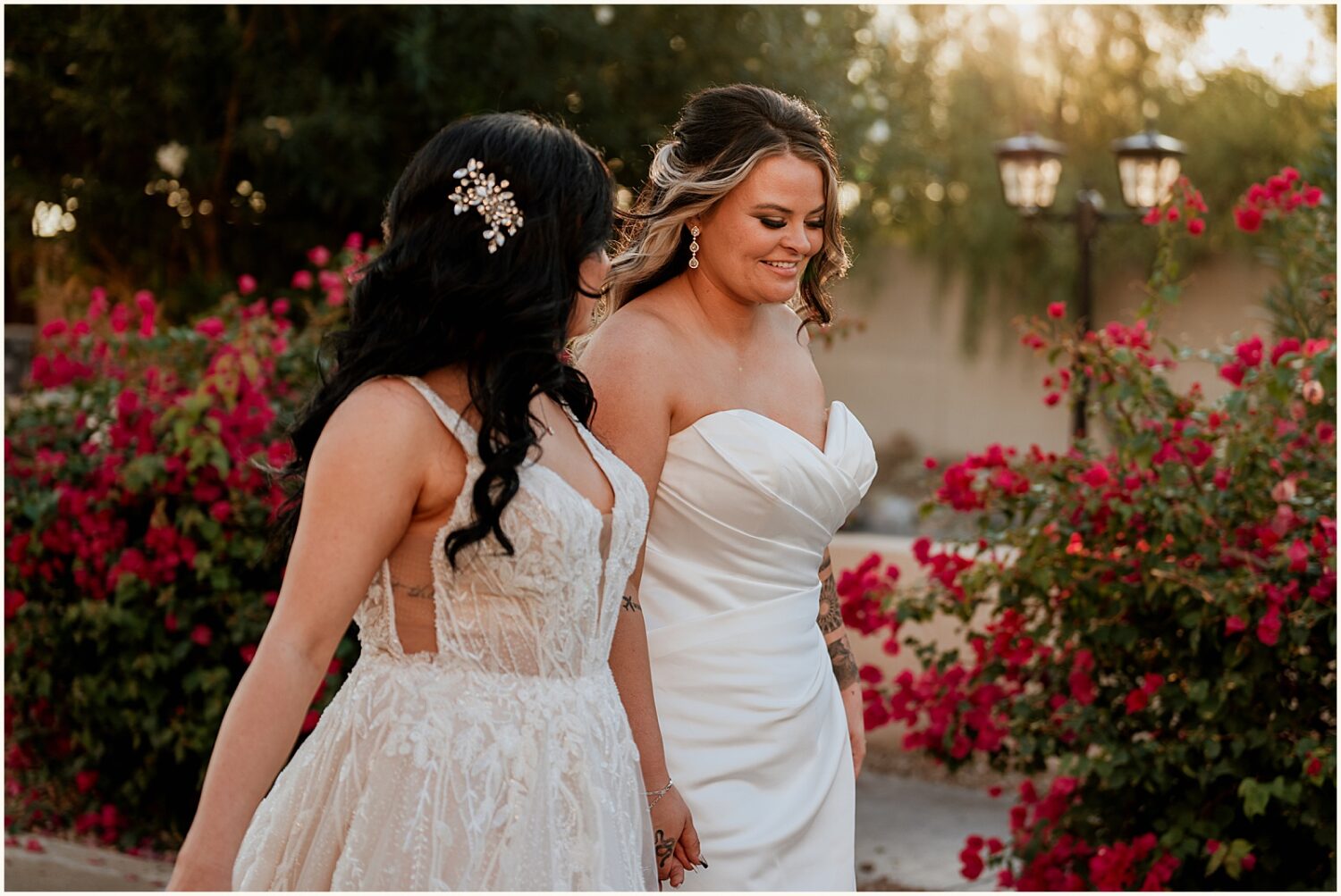 Two brides walk through the courtyard at Superstition Manor.