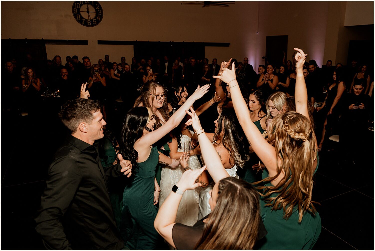 Wedding guests dance in a circle around a bride.