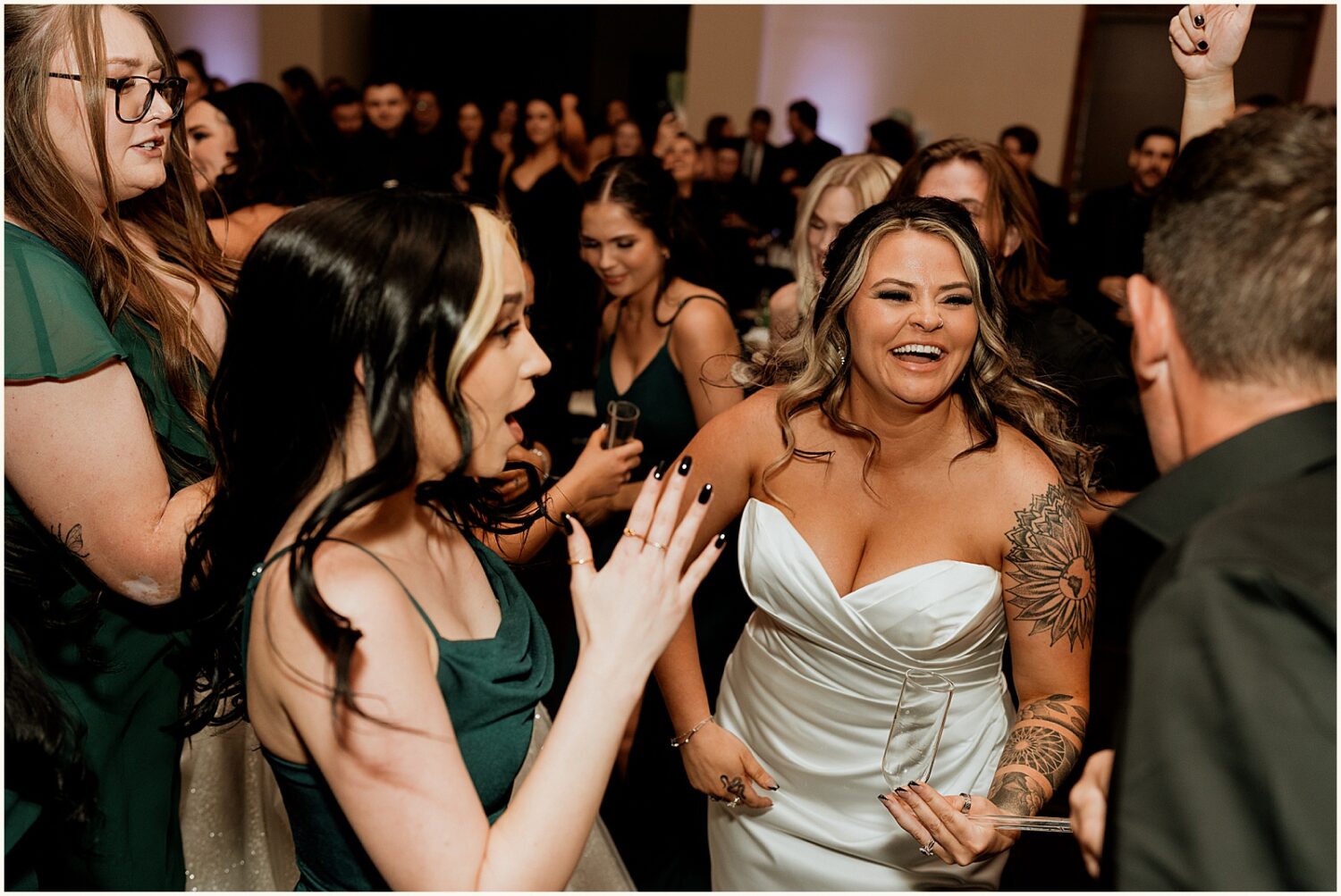 A bride laughs with a bridesmaid.