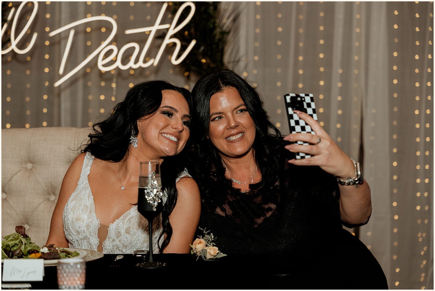 A guest takes a selfie with a bride.