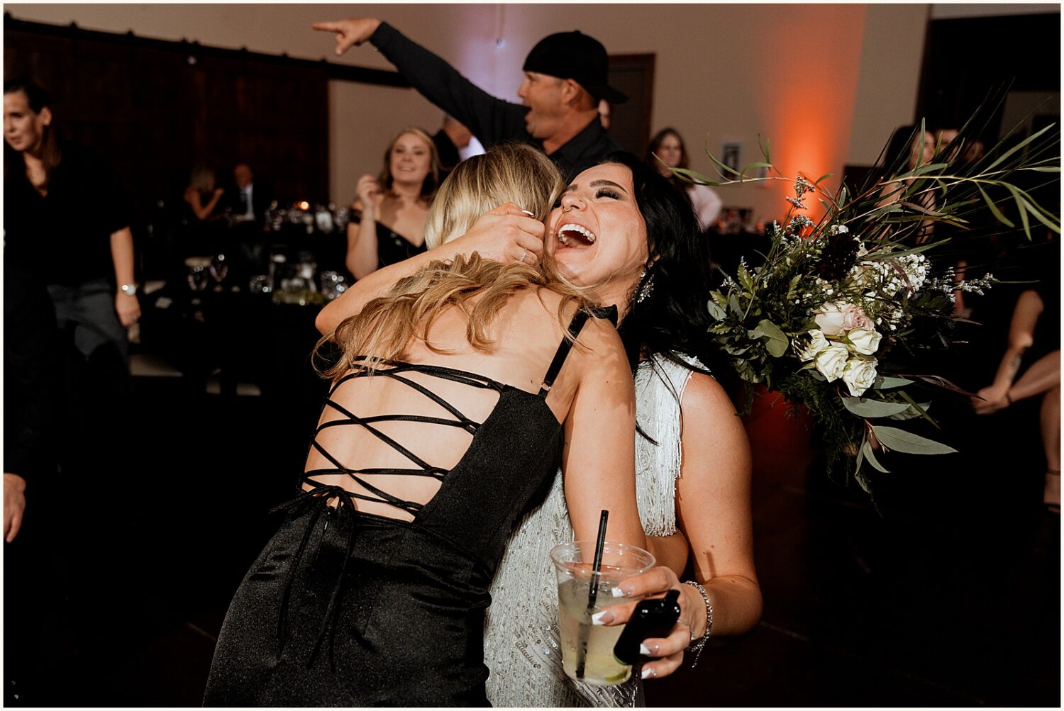 A bride hugs a guest.